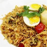 Egg Biryani · Boiled egg cooked with vegeatbles, rice, and spices served with yoghurt dip and spicy sauce.