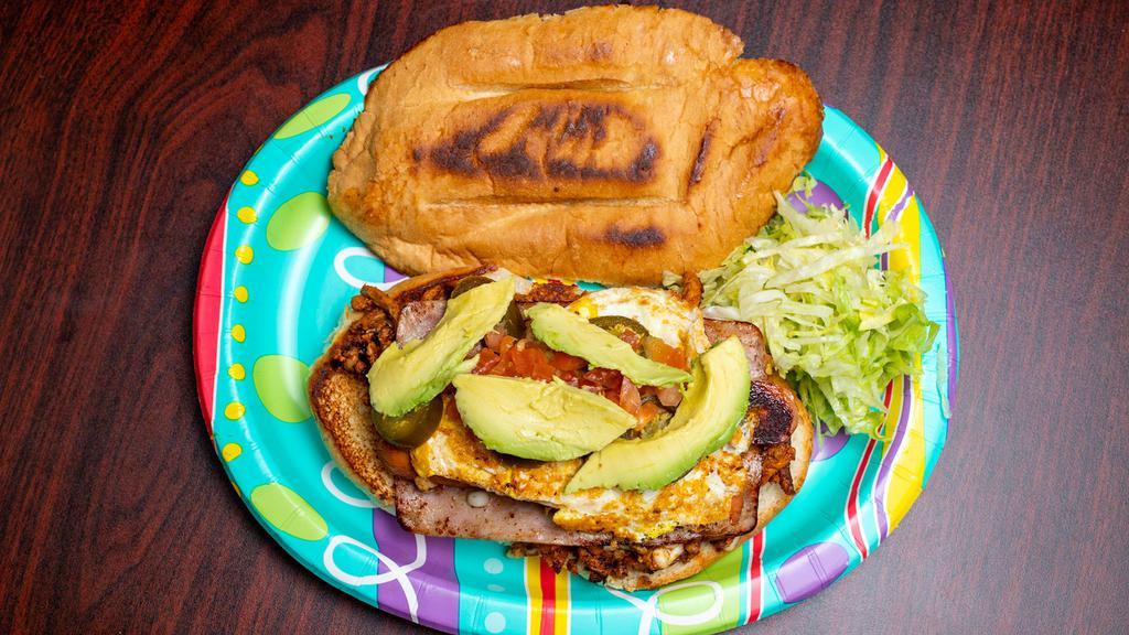 Torta Cubana · Choice of meat along with ham, sausage (hot dog franks) and fried egg (well done). Torta includes avocado, cheese, jalapeños, lettuce, mayo and tomatoes