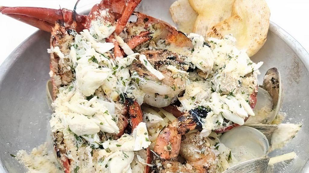 Lobster Tchoupitoulas · Whole grilled lobster with clams, shrimp, lump crab meat and linguini topped with garlic butter and parmesan.