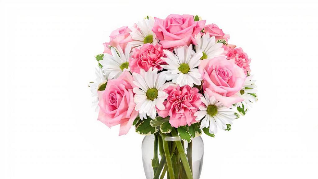 Daisies & Roses Delight (Pink) - Designers Choice · Delight her to this undeniably charismatic combination of roses and daisy poms. Brighten her with a wonderful expression of happiness and cheer! Accented with lush greens and presented in a classic clear glass vase, this floral arrangement is a beautiful way to celebrate any mom or mom-figure.
Note: This designer's choice arrangement may consist of all red, yellow or pink roses or a combination of the three colors based upon product availability.