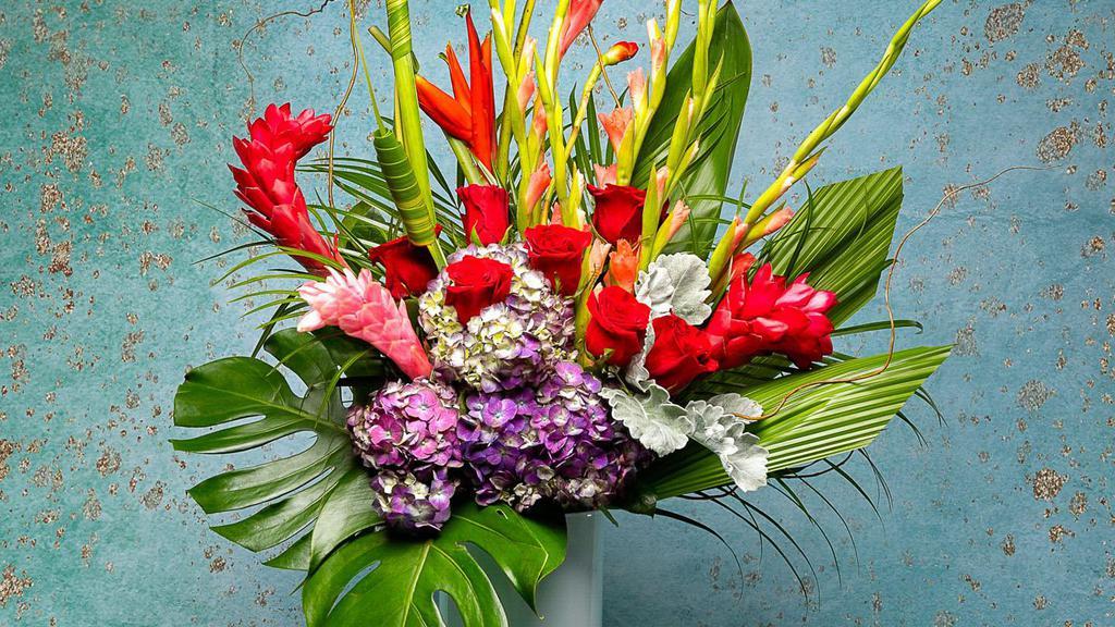 Tall Tropical Tranquility W/Roses · Enjoy this beautiful Tall Tropical Tranquility mix With Red or Any color Roses 
arrangement as you are swept away to your happy place.
Flowers included: Roses, Red Ginger, Hydrangeas, Green Orchids and Bird of Paradise.
Designed beautifully and placed in a modern oval shaped vase with rocks in the bottom.