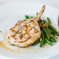 Pork Chop · Double bone served with mashed potatoes, green beans and topped with caramelized red onions.