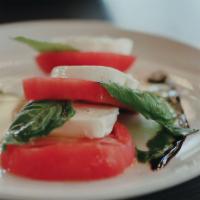 Tomato Caprese · Heirloom tomatoes tossed with fresh basil, balsamic vinegar, extra virgin olive oil, and moz...