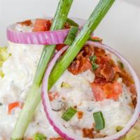 Wedge Salad · Iceberg lettuce topped with crispy bacon, green onions, blue cheese dressing, and crumbles.