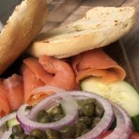 Lox Bagel · Toasted bagel topped with red onion, capers, sliced tomato and mild cold-smoked lox salmon.