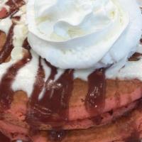 Red Velvet Pancakes · Red velvet batter pancakes with white chocolate chips and topped with cream cheese frosting.
