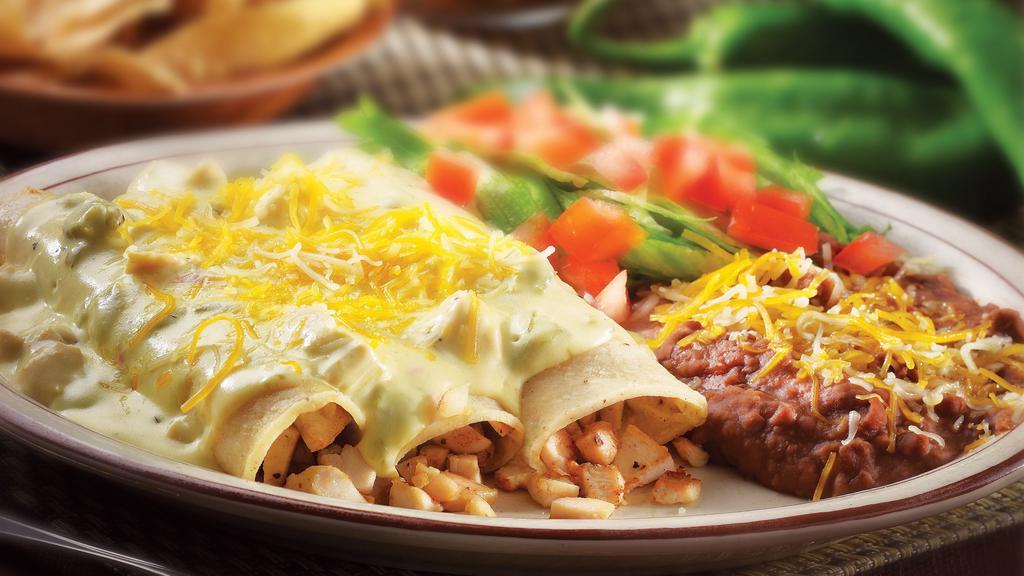 Green Chile Chicken Enchiladas · Tender chicken, sautéed onions, cheese rolled in corn tortillas topped with our signature sour cream green chile sauce and cheese. Served with chips and salsa.