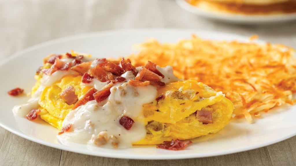 Country Music Star Omelette · House-made sausage, diced ham, and onions, topped with cheddar and Monterey Jack cheeses, country gravy and chopped bacon.