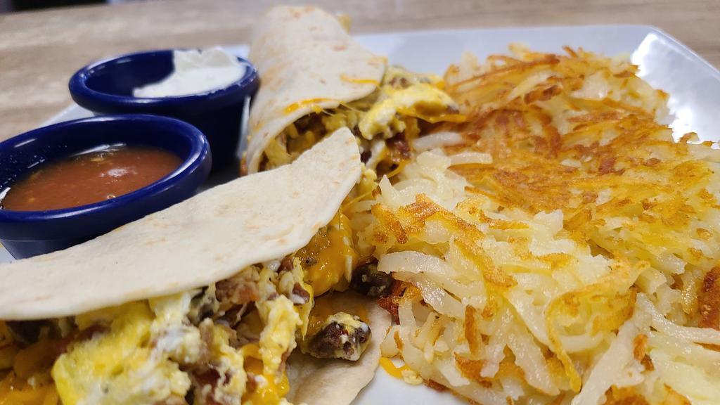 Breakfast Tacos · 2 warm flour tortillas packed with 3 scrambled eggs, bacon, sausage, and cheese served with salsa, sour cream and choice of side