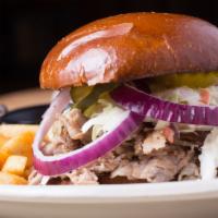 Pulled Pork Sandwich · smoked pulled pork, bbq sauce, slaw, purple onion and pickles on top. Served with fries.