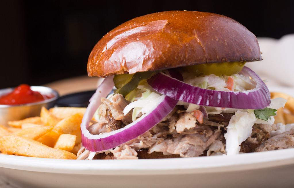 Pulled Pork Sandwich · smoked pulled pork, bbq sauce, slaw, purple onion and pickles on top. Served with fries.