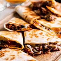 Chicken Or Beef Quesadilla · Flavorful and tender, our marinated beef or chicken is smothered in cheese, drizzled with ou...