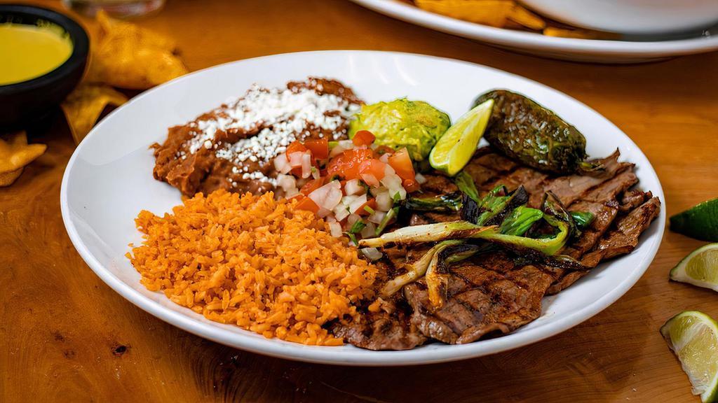 Carne Asada · Signature carne asada with a side of rice and refried beans, pico, whole roasted jalapeño, guacamole, and tortillas.