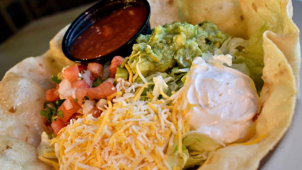 Crispy Taco Salad · A fried tortilla bowl filled with refried beans, crisp lettuce and your choice of shredded chicken or seasoned ground beef. Topped with sour cream, guacamole, cheese and pico de gallo.