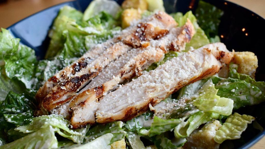 Mexican Caesar Salad · A large bowl of crisp romaine lettuce tossed in caesar dressing, shaved parmesan cheese and garlic croutons. Topped with grilled chicken fajita.