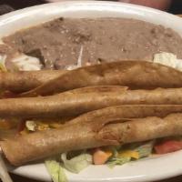 Chicken Flautas · On a bed of lettuce topped with sour cream and avocado sauce. Served with rice and beans.