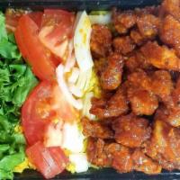 Popcorn Chicken Over Rice · Served with our Signature Exotic Basmati Rice, Lettuce, Onions, Tomatoes, Red Cabbage, and a...