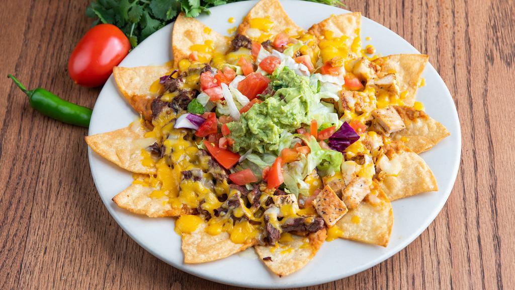 Nachos Especiales · Twelve large corn tortilla chips topped with beef fajita or chicken fajita, beans, cheese, guacamole, lettuce and tomatoes.