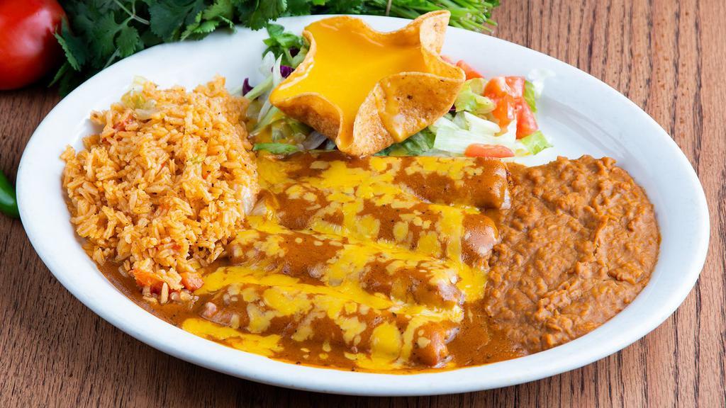 Tamales · Four pork tamales topped with gravy and cheese. Served with rice, beans, and a cheese puff.