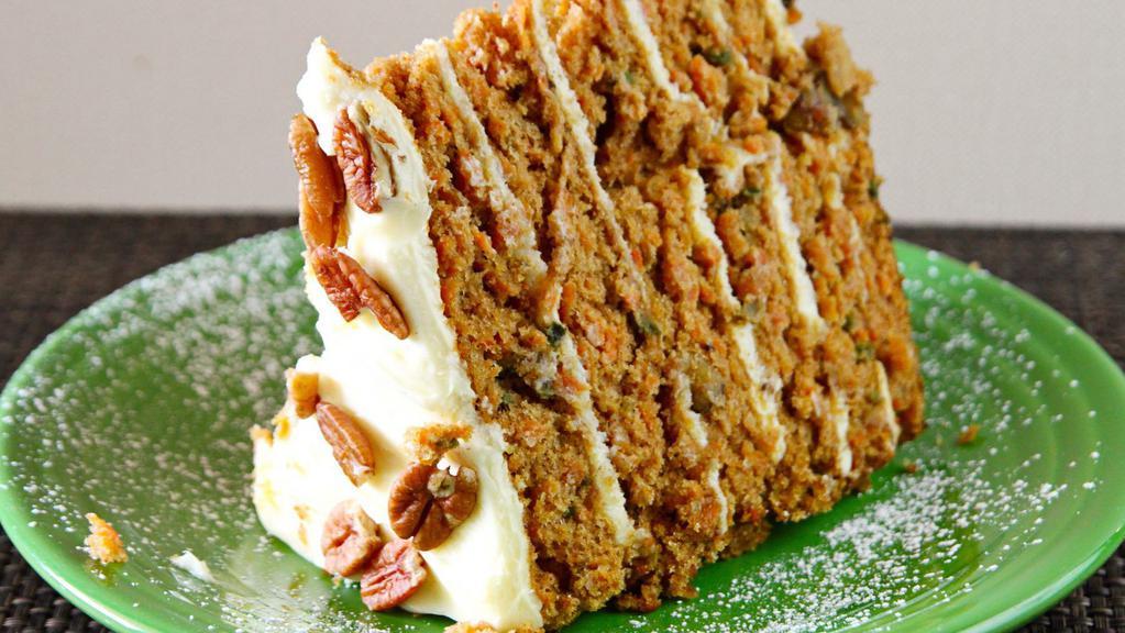 Big Carrot Cake · Subtly spiced and generously covered with cream cheese icing. This delectable cake is filled with freshly grated carrots, sweet crushed pineapple, and chopped walnuts. Dusted with powdered sugar.