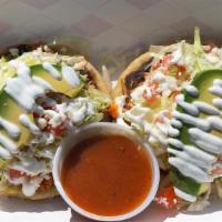 Sopes · Two sopes, topped with black bean  spread, lettuce, tomato, queso fresco, avocado and sour c...