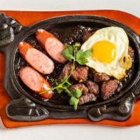 House Sizzling Beef Steak · Bò né. Marinated steak, an egg, and sausage on hot plate, served (lettuce, cucumber and toma...