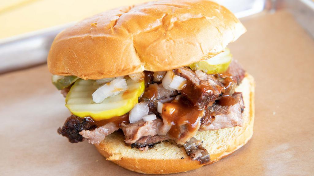 Texas O.G · The classic Texas BBQ sandwich. Prime angus brisket topped with pickles, onions and backyard red. Your choice of sliced or chopped brisket.