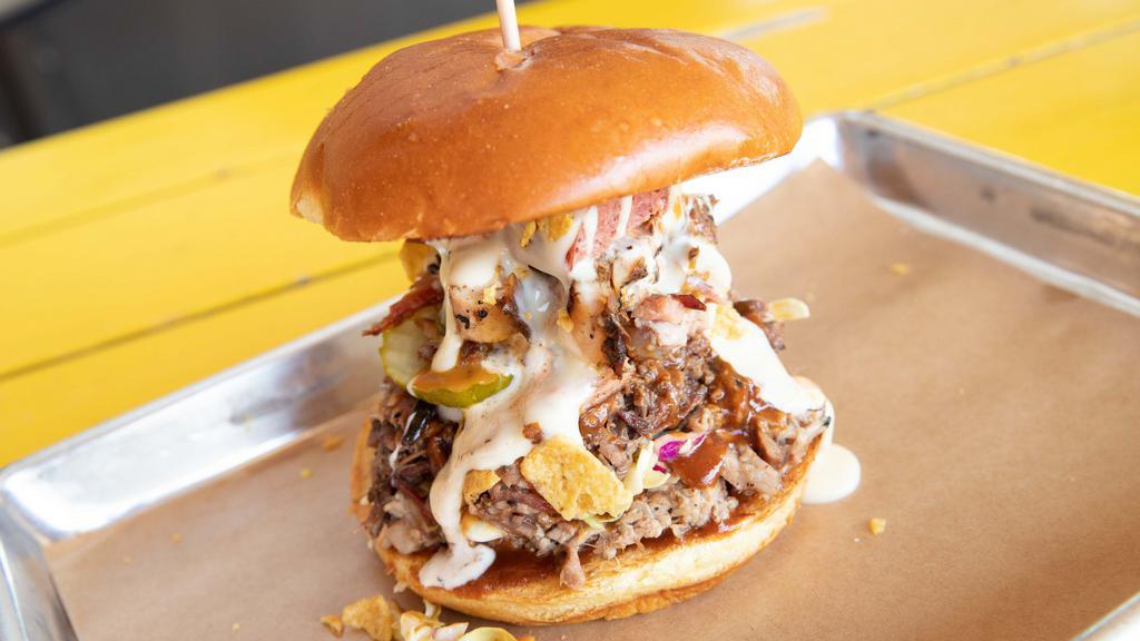 The Donk · One pound sandwich stacked with every slab smoked meat available & topped with pickles, onions, jalapenos, queso, Fritos & all of our slab BBQ sauces.