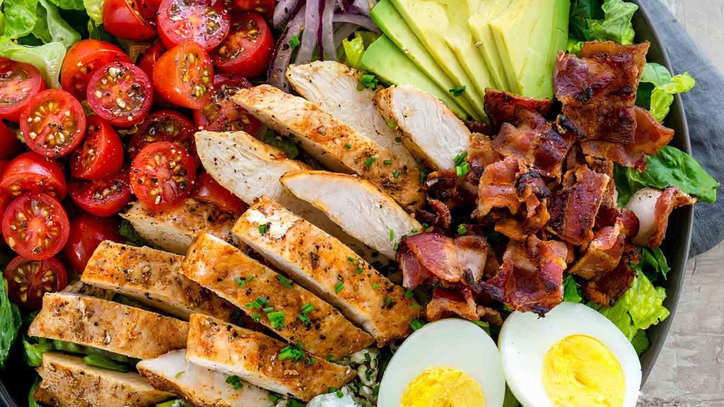 Cobb Salad · Mixed greens with grilled chicken, avocado, diced tomato, crispy bacon bits, blue cheese crumbles, hard-boiled egg, and house vinaigrette.