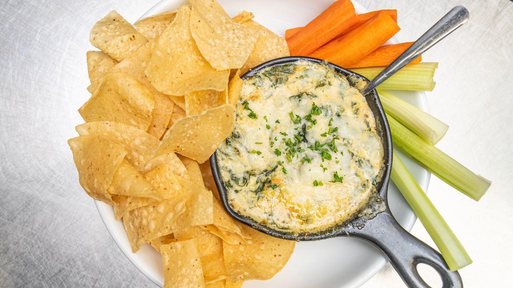 Spinach & Artichoke Dip · Three cheese blend, roasted garlic, spinach & artichoke, served with house chips, carrots & celery.