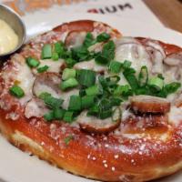 Saucer Bratzel · One pretzel topped with melted Swiss cheese, sliced bratwurst, and green onions.  Served wit...