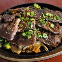 Korean Bbq Short Ribs (Kalbee) · Grilled short ribs served on a skillet made with house special sauce and a side of steamed r...