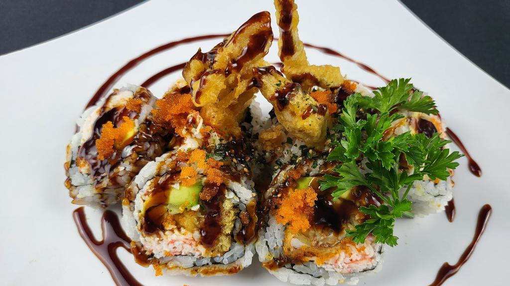 Spider Roll · (IN - Deep fried soft shell crab, with cucumber, crabmeat, avocado) ,  
(Out - Eel sauce and masago on top)