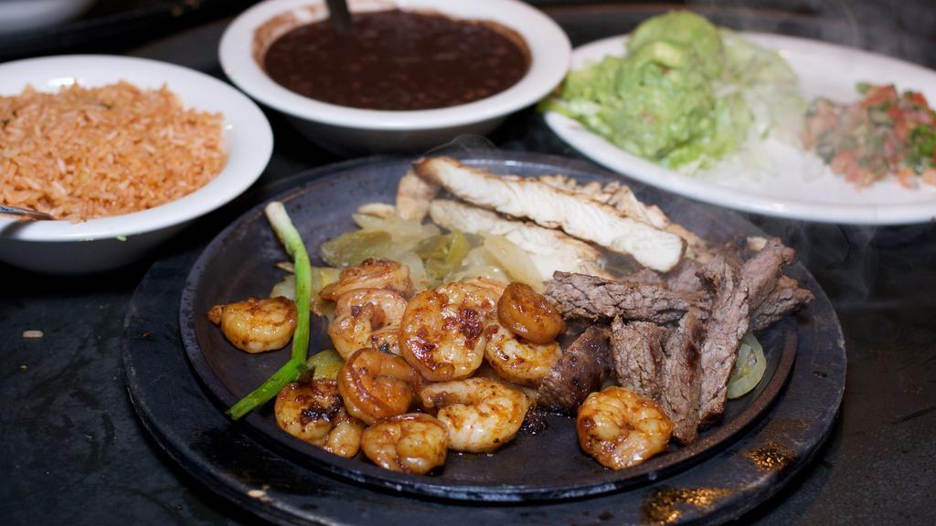 Fajita Trio · Alamo Cafe favorite. A combination of our famous char-broiled  chicken, beef and shrimp  with sautéed bell peppers and onions. Served with fresh tortillas, sliced avocado,  pico de gallo, rice and black beans.