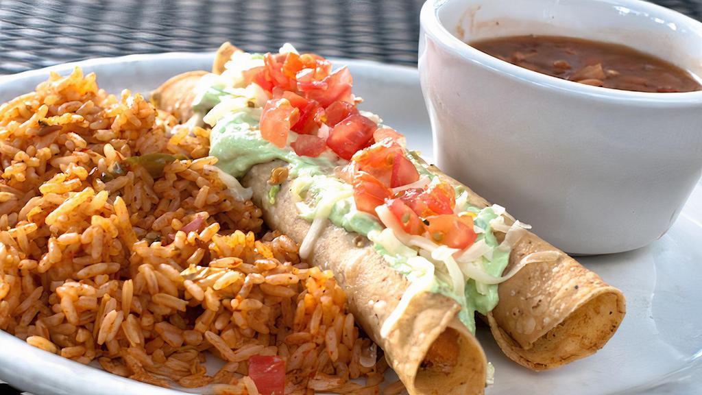 Flautas · Tightly rolled corn tortillas filled with seasoned chicken in a mild red sauce. Fried crisp and topped with guacamole sauce, Monterey Jack cheese, and diced tomatoes. Served with rice and borracho beans.