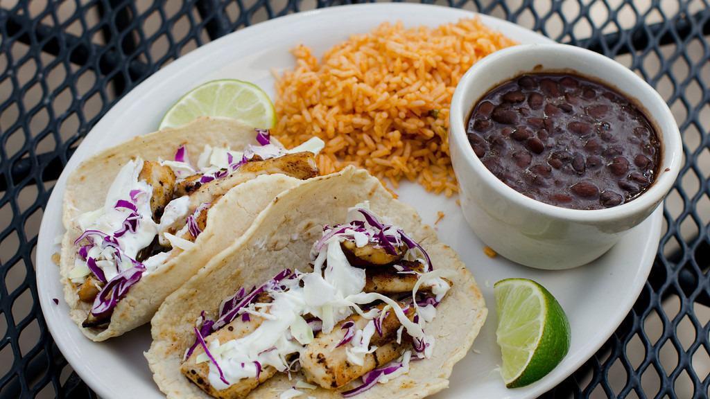 Fish Taco Dinner · Seasoned pieces of tilapia grilled to perfection, served in our homemade corn tortillas, with a cabbage slaw and our cilantro lime cream sauce. 
Served with black beans and rice.