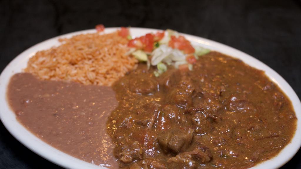 Carne Guisada · Spicy Mexican-style beef stew.  Served with rice and refried beans.