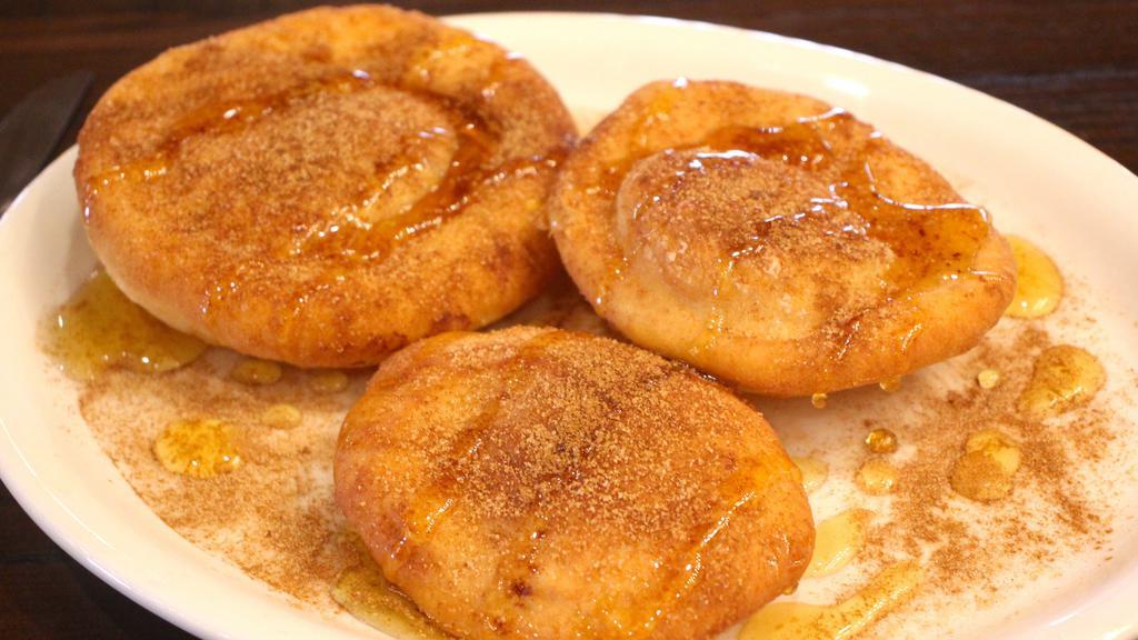 Sopapillas · Warm, crisp bread puffs dusted with cinnamon sugar and covered in honey.