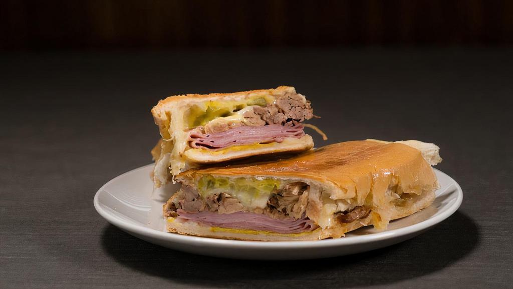 Cubano · Roasted pulled pork, ham, Swiss cheese, pickles, mayo, and mustard. Sandwiches are served with lays chips and on a Cuban bread pressed to perfection.