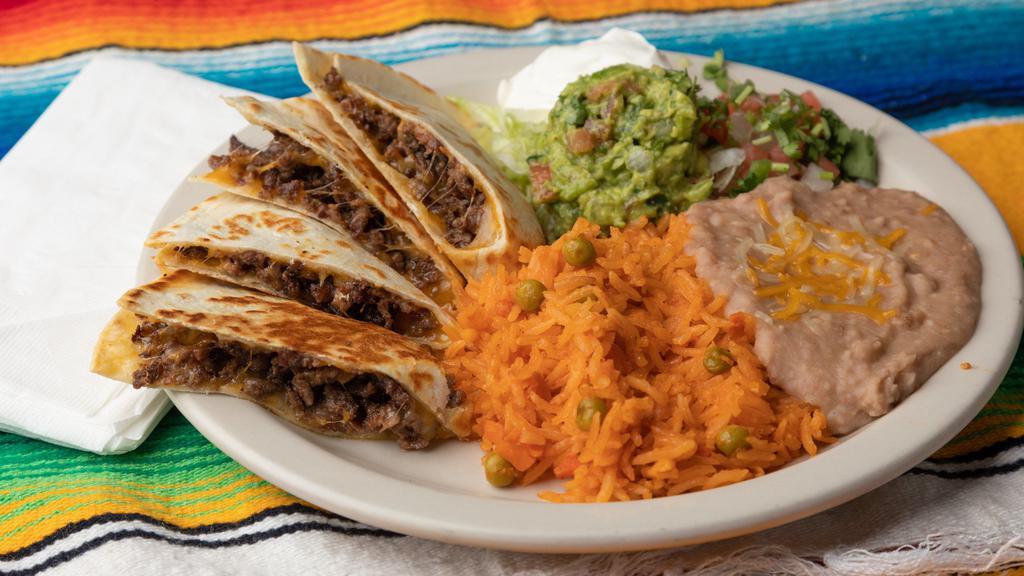 Quesadillas · Choice of meat served with pico de gallo, sour cream, guacamole rice and beans.