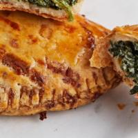 Spinach Ricotta Empanada · An empanada filled with spinach, ricotta, asiago, red bell peppers, onion, and garlic. Arriv...
