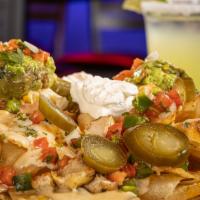 Ultimate Nachos · Warm tortilla chips topped with mexican blend of cheese, queso, pico de gallo, jalapeños. Se...