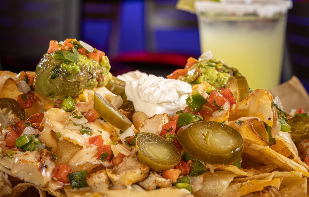 Ultimate Nachos · Warm tortilla chips topped with mexican blend of cheese, queso, pico de gallo, jalapeños. Served with sides of salsa and sour cream.