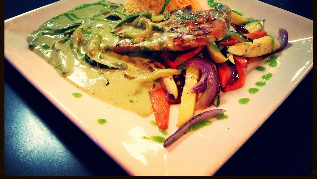 Pollo Puebla · Grilled chicken breast, slowly marinated with Mexican herbs, topped with poblano pepper sauce over sautéed vegetables and rice.