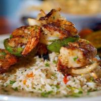Bacon Wrapped Shrimp Skewers · Three skewers of bacon wrapped wild-caught shrimp. Served with coastal rice and grilled vege...