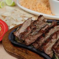 Sizzling Fajitas · A half pound of wood-grilled fajitas, roasted onions and peppers. Served sizzling with coast...