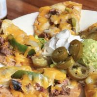 Beef Fajita Nachos · Loaded with Mesquite Grilled Beef Fajitas, mixed cheese, roasted peppers and onions, refried...