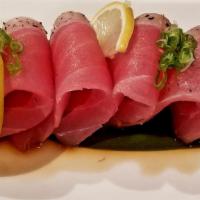 Pepper Tuna Tataki · Seared peppered tuna topped with sesame seeds, green onion and ponzu sauce.