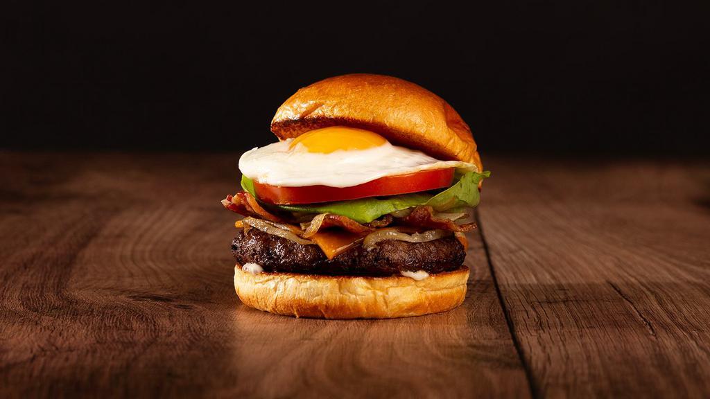 The Breakfast Burger · Beef patty, bacon, caramelized onions, melted cheddar cheese, mayo, and a fried egg on a brioche bun.