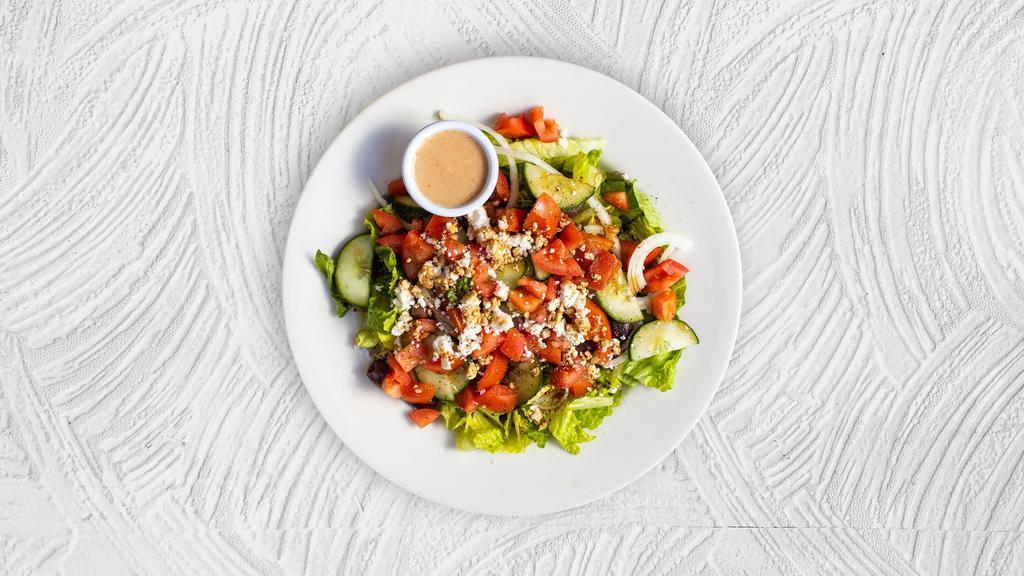 Greek Town Salad · Tender hearts of romaine tossed with a Greek oregano vinaigrette, topped with creamy feta cheese, cherry tomatoes, peeled cucumbers, pitted Kalamata olives, and red onions.